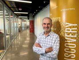 A person standing in a hallway with his arms crossed